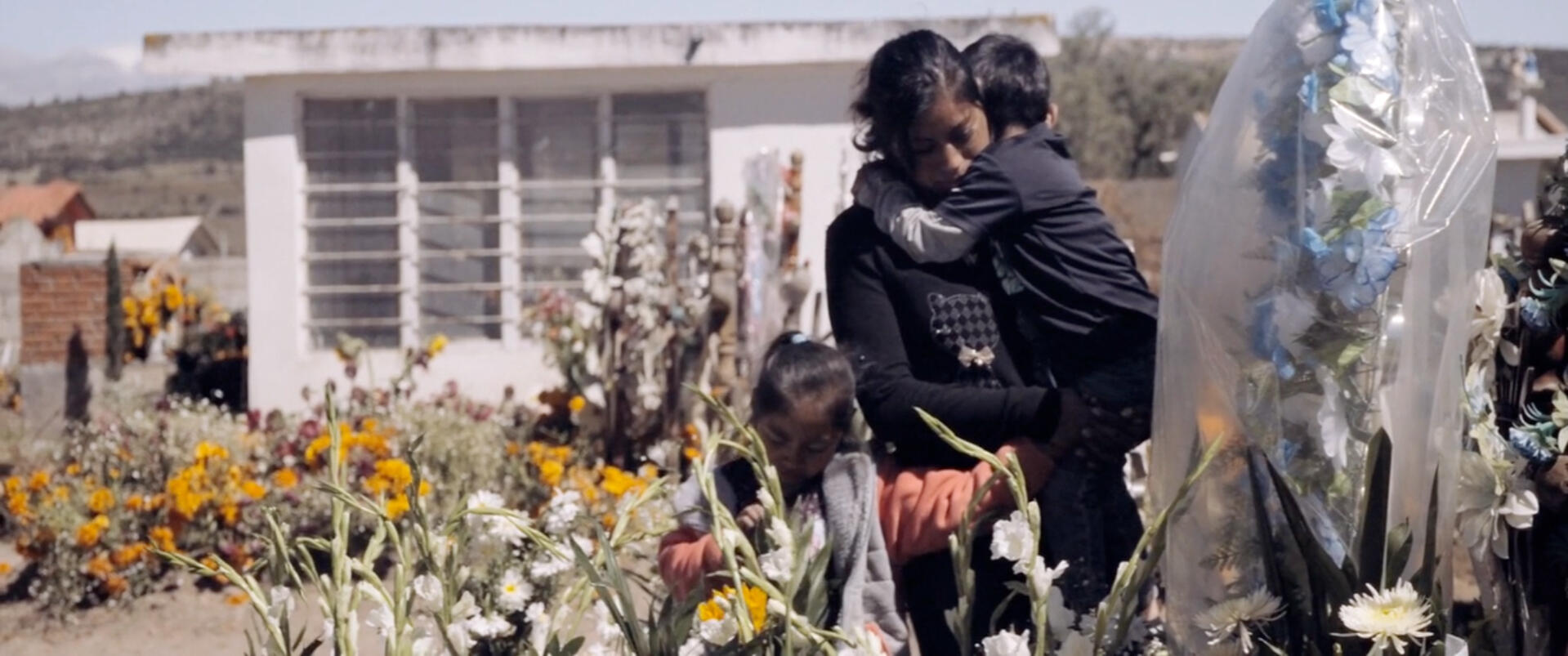 Martha placing flowers for Valentín